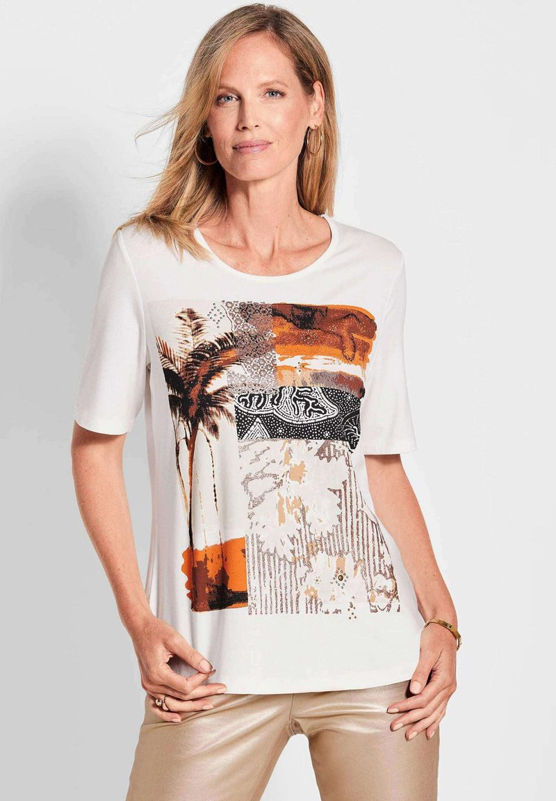 Korte mouw witte T-shirt met een kleurrijke grafische print in aardetinten, waaronder oranje en zwart, en gestructureerde patronen.