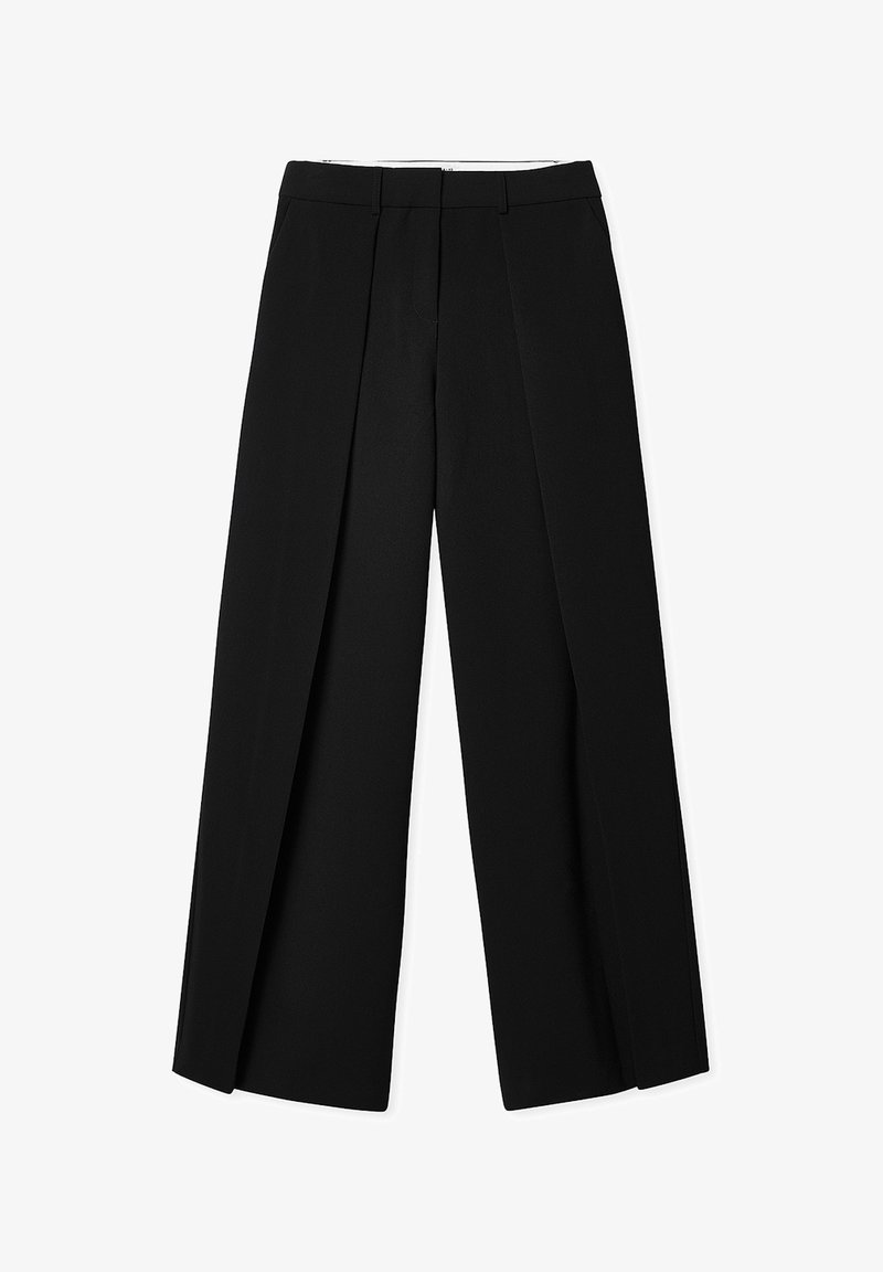 Pantalones negros de corte ajustado con pata ancha, que presentan pliegues frontales y una textura suave. Tienen una cintura ajustada y sin herrajes visibles.