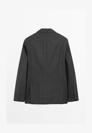 Blazer gris cintré en tissu texturé. Présente un col cranté, des manches longues et deux boutons aux poignets. Design épuré et simple.