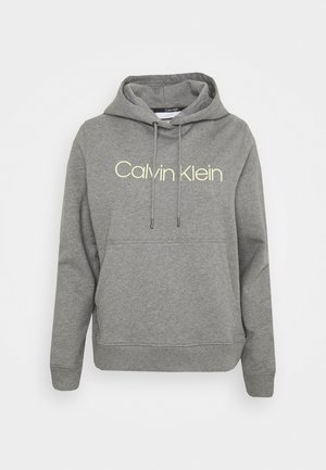 Szara bluza z kapturem, wykonana z miękkiego materiału, z kieszenią typu kangur, regulowanymi sznurkami i logo "Calvin Klein" w jasnym żółtym kolorze.