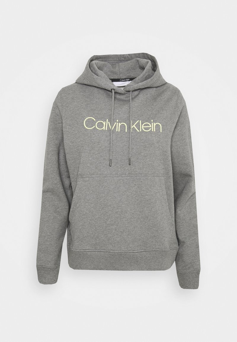 Grå hoodie gjord av mjukt tyg, med en känguruficka, justerbara dragsko och "Calvin Klein"-logotyp i ljusgul.
