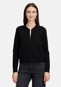 Zwarte zip-up cardigan van textuurstof, met een ronde halslijn, twee voorzakken en lange mouwen.