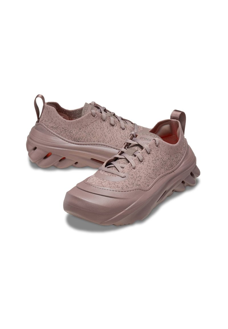 Helle rosafarbene Sportschuhe mit einem strukturierten Strick-Obermaterial, gepolsterten Sohlen und einem abgerundeten Sohlendesign für zusätzlichen Komfort und Flexibilität.