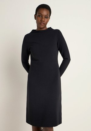 Schwarz, geripptes Langarmkleid mit hohem Ausschnitt und tailliertem Schnitt, das bis knapp über das Knie reicht. Glattes Gewebe, minimalistisches Design.