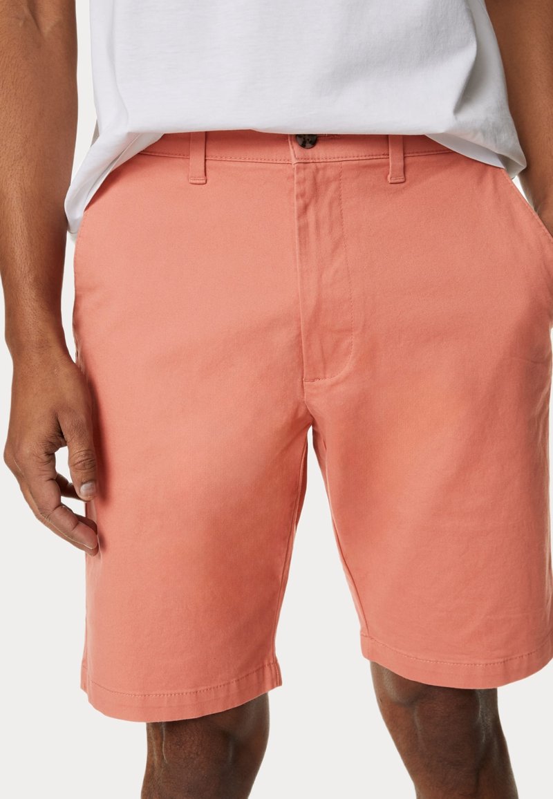 Shorts pour hommes en corail en tissu léger, dotés d'un devant plat, de passants de ceinture et d'un ourlet cousu. Design décontracté adapté aux temps chauds.