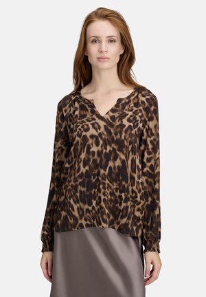 Blouse à manches longues, imprimé léopard brun et noir, avec un décolleté en V et des poignets élastiqués, fabriquée en tissu léger, ajustement légèrement ample.