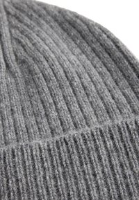 Szara dziana czapka beanie z prążkowanym teksturem, wykonana z miękkiego materiału, z lekko puszystym wykończeniem. Podkreślona poziomym detalem szwu.