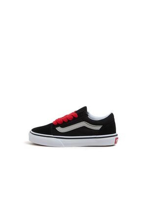 Zapatilla negra de caña baja con franja blanca en forma de ola, cordones rojos, suela blanca y lengüeta roja en el talón sobre fondo blanco.