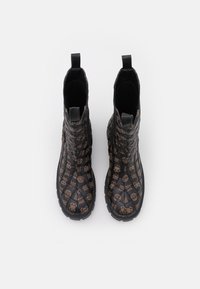 Zwarte enkelboots met een textuur, voorzien van een patroon van schedels in bruin. Trek lusjes aan de zijkanten voor eenvoudig aan- en uittrekken.