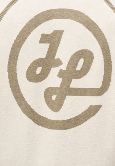 Μπεζ διασταυρωμένα πεζά γράμματα "j" και "f" μέσα σε μερικό κύκλο πάνω σε φόντο κρεμ υφάσματος.