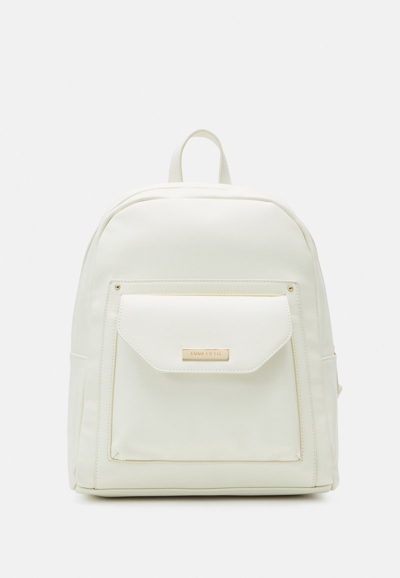 Sac à dos blanc en matériau lisse, comportant une poche avant avec un accent en métal doré. Conçu avec des bretelles ajustables.