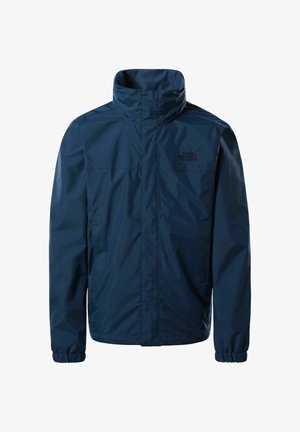 Veste imperméable bleu marine avec col haut, poignets élastiques, fermeture éclair avant cachée par un rabat tempête, et logo The North Face sur la poitrine gauche.