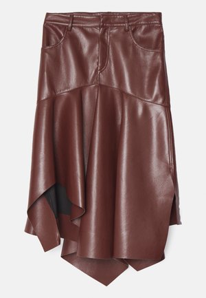 Saia em pele sintética castanha com uma bainha assimétrica e com godê, apresentando dois bolsos frontais e uma textura lisa e brilhante.
