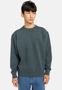 Felpa verde scuro realizzata in materiale misto cotone, con collo rotondo, maniche lunghe e un logo del marchio discreto sul petto.
