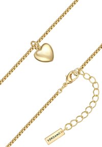 Złota bransoletka z gładkim serduszkiem i bezpiecznym zapięciem na zatrzask. Posiada regulowaną długość z ogniwami łańcucha i metką.