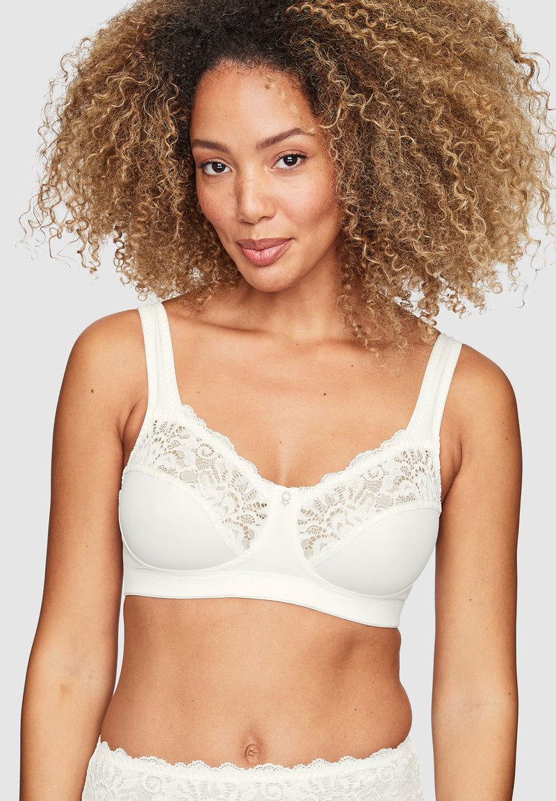 Witte beha met kantaccenten, brede banden en een naadloos ontwerp. Kenmerkt zich door een zachte textuur en delicate scalloped randen langs de halslijn.