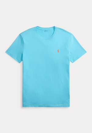 Light blue cotton t-shirt with a crew neck, short sleeves, and a small orange embroidered logo on the left chest. Smooth texture.
