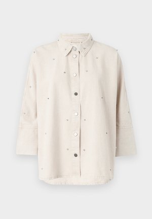 Light beige denim shirt featuring a button-up front, classic collar, and three-quarter sleeves. Adorned with small decorative studs.