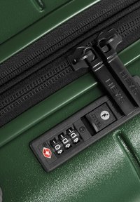 Valigia rigida verde con finitura testurizzata, dotata di doppie cerniere nere e un lucchetto a combinazione nero con un dettaglio logo rosso.