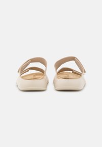 Scarpe slip-on beige con un'esterno liscio in plastica. Presentano due cinturini regolabili e una soletta testurizzata per il massimo comfort.