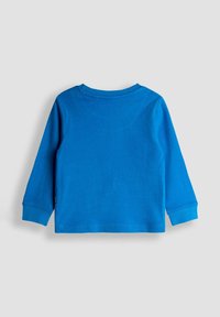 Cămașă cu mânecă lungă din bumbac de culoare albastră strălucitoare, cu decolteu rotund și finisaje cusute. Textură netedă, fără modele sau detalii metalice.