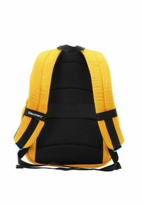Mochila acolchada amarilla con respaldo de malla negra y correas ajustables. Presenta una etiqueta de logo y un diseño estructurado y ergonómico.