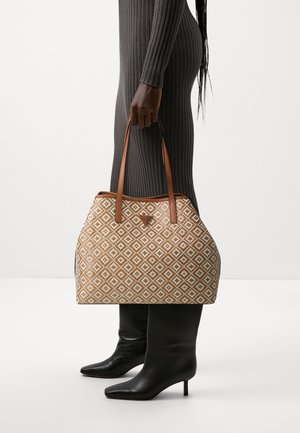 Le sac fourre-tout présente un motif géométrique en marron et blanc, avec des poignées en cuir beige. Le sac a une silhouette structurée et une texture lisse.