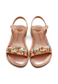 Sandalias en color oro rosa con suela plana, que presentan una tira de cuentas adornada con cuentas de colores y perlas. Incluye una correa ajustable para el tobillo.