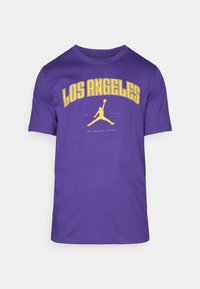 Violets kokvilnas T-krekls ar uzrakstu "LOS ANGELES" dzeltenā krāsā un melnu Jordan logotipu priekšpusē. Īsām piedurknēm un apaļas kakla dizains.