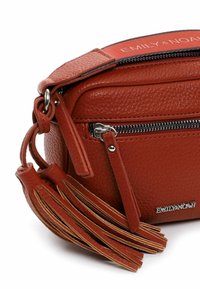 Borsa a tracolla in pelle marrone con texture, dalla forma arrotondata, zip argentata e frange decorative. Presenta il nome del marchio impresso in metallo.