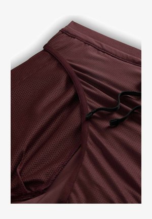 Bordeauxfarvede træningsshorts med en struktureret, netlignende stof. Har en elastisk talje med justerbare sorte snore og en glat inderside.