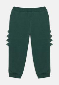 Green sweatpants with a ribbed waistband. Features textured triangular accents along the side seams. Soft material, tapered cuffed legs.
