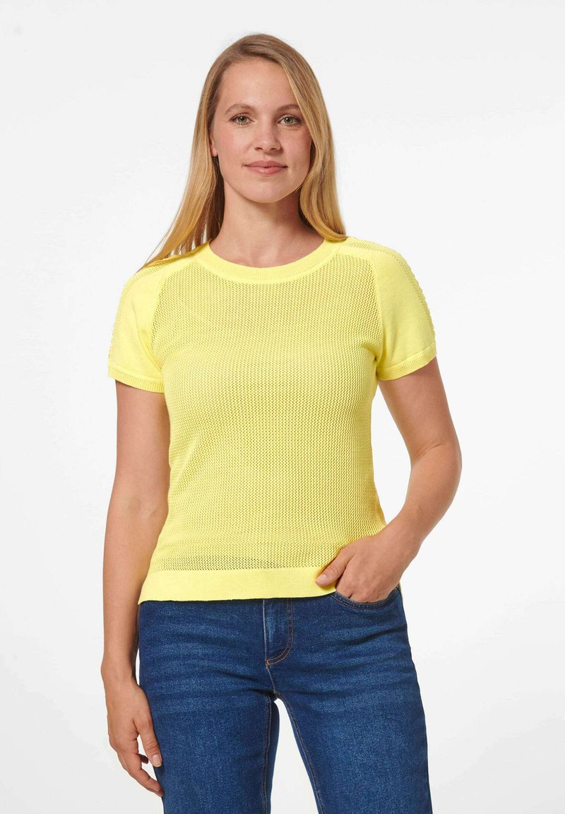 Geel gebreid shirt met korte mouwen en een textuurpatroon, ronde hals en ribbelaccenten. Gecombineerd met blauwe jeans. Eenvoudig en ademend ontwerp.