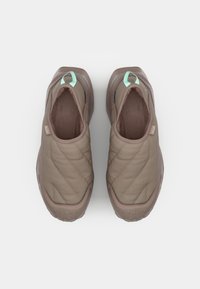 Bottines marron matelassées à enfilage avec un dessus texturé et des accents vert clair. Présentent un intérieur doux et une semelle en caoutchouc avec des détails en motif.