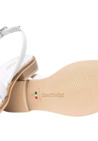 Sandal in pelle bianca con cinturino alla caviglia regolabile, soletta in sughero e suola in gomma texturizzata. Presenta dettagli con marchio e misura 37.
