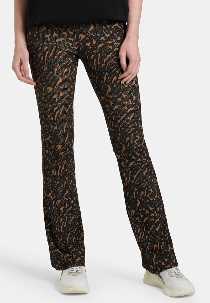 Rozšířené černé kalhoty s hnědým abstraktním vzorem, vyrobené z texturovaného materiálu. Mají vysoký pas a úzký střih přes stehna.