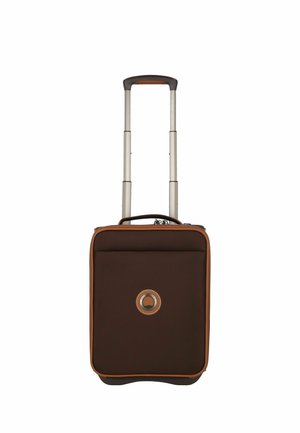 Brown wheeled suitcase with padded exterior, silver retractable handle, brown accents, and a circular logo on the front.