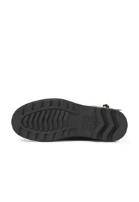 Semelle de chaussure en caoutchouc noir avec un motif de semelle profond, taille 40, et le nom de la marque "Aigle" moulé dans la semelle, photographiée sur fond blanc.