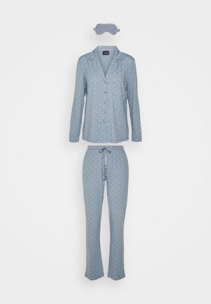 Set di pigiama blu con pois bianchi, composto da una camicia a maniche lunghe, pantaloni con vita regolabile e una mascherina per dormire coordinata.