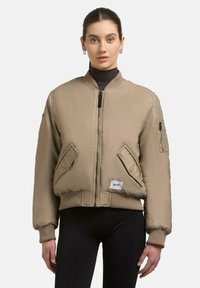 Beige Bomberjacke mit Reißverschluss, gerippten Bündchen und zwei Fronttaschen. Mit einer aufgesetzten Tasche am Ärmel und einem Logo-Label am Saum.