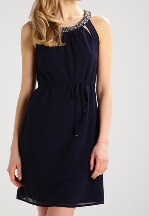 Granatowa, bezrękawnikowa sukienka z wycięciem w kształcie klucza i zdobionym kryształkami dekoltem. Posiada ściągacz w talii oraz miękki, zwiewny materiał.