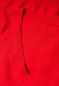 Rode V-hals sweater van zachte stof, met een gladde textuur en een geribde halslijn, zonder verdere patronen of accenten.
