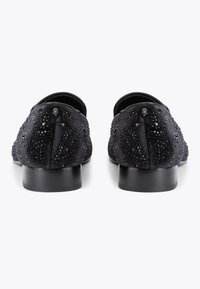 Czarne satynowe mokasyny z teksturowaną powierzchnią, ozdobione koralikami i niskim czarnym obcasem, prezentujące elegancki, gładki design.