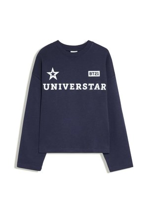 Chemise à manches longues bleu marine avec texte blanc "UNIVERSTAR,", un graphique étoile et une étiquette "BT21" sur la poitrine.