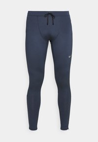 Collants de sport Nike bleu marine avec taille à cordon noir et petit logo swoosh réfléchissant sur la cuisse gauche.
