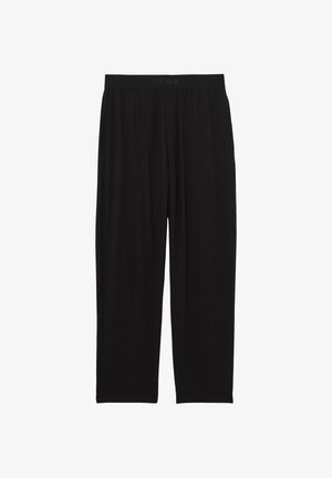 Person trägt schwarze Hose mit elastischem Bund und der Aufschrift "REISS", Hand in der Seitentasche, gezeigt von der Taille bis zur Mitte des Oberschenkels.
