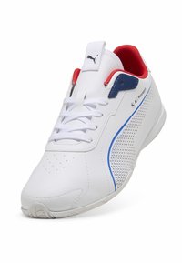 Hvide sneakers med perforeret design, blå og røde akcenter, flade snørebånd og polstret krave. Gummisål med struktureret grebmønster.