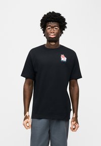 Μαύρο βαμβακερό μπλουζάκι με πολύχρωμο σχέδιο παγωτού στο αριστερό στήθος, στρογγυλή λαιμόκοψη και κοντά μανίκια.