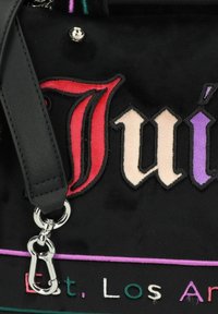 Borsa in tessuto nero con lettere ricamate colorate in rosso, crema e viola. Include una tracolla nera e dettagli in metallo argentato.
