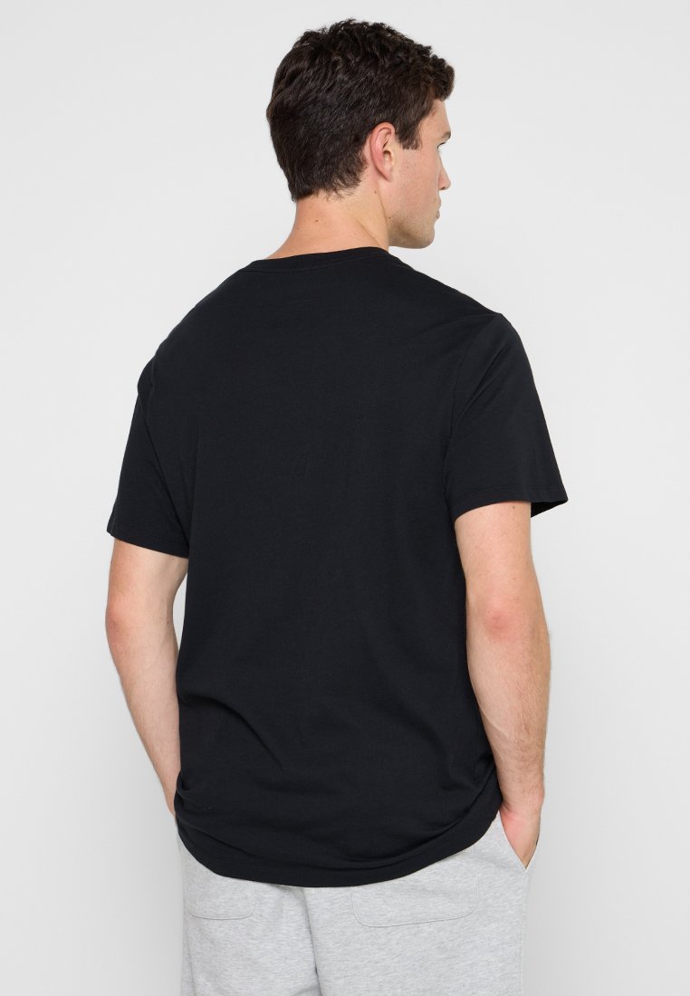 Schwarzes Baumwoll-T-Shirt mit kurzen Ärmeln und rundem Ausschnitt, das eine glatte Textur und ein schlichtes, ungeschmücktes Design aufweist.